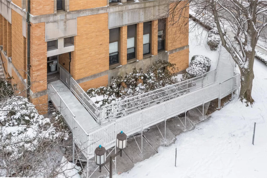 Commercial building with aluminum wheelchair access ramp with snow
